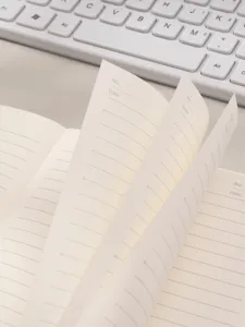 Detalle de las páginas de un cuaderno de líneas crema con encabezados de fecha y número.