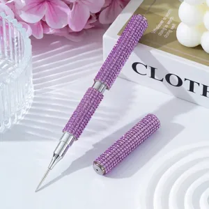 Detailed macro view of a purple rhinestone nail art dotting pen with a fine metal needle tip