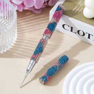 Close-up of a double-ended nail art pen with colorful rhinestone handle for dotting and lining.
