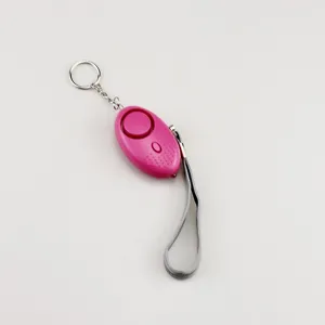 Close-up detail view of pink egg-shaped personal alarm with metal keychain and grey wrist strap