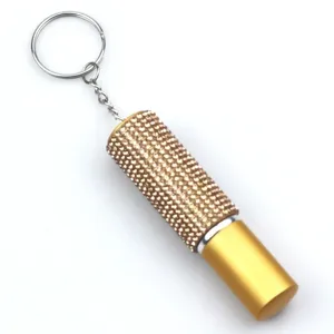 Close-up of a 5ml mini gold perfume atomizer with sparkling pink rhinestones and keychain.