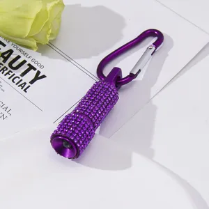 Close-up of stylish purple rhinestone mini LED flashlight with carabiner keychain