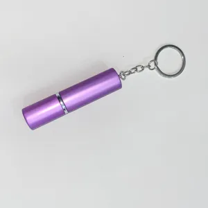 Detalle de un atomizador de perfume púrpura de 5ml con llavero metálico portátil