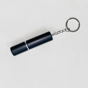 Detalle de un elegante atomizador de perfume portátil de 5ml negro mate con llavero