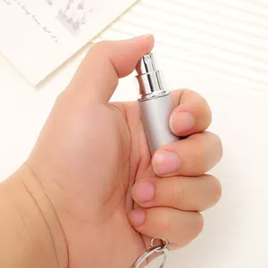 Detailed macro view of a 5ml silver portable mini perfume spray bottle held in hand