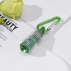Detailed macro view of green mini LED flashlight with sparkling rhinestones and clip