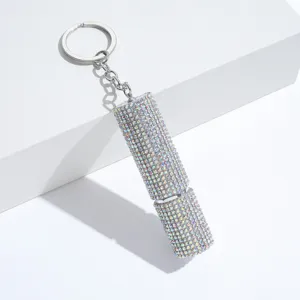 Detailed view of iridescent rhinestone-encrusted lipstick-shaped perfume atomizer keychain