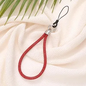 Detailed view of luxury 6mm red rhinestone phone wrist strap on textured fabric