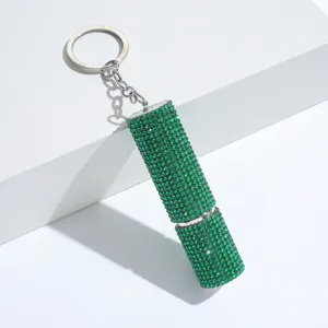 Close-up of a sparkling green rhinestone-encrusted perfume atomizer keychain.