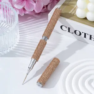 Macro view of a luxury champagne rhinestone-encrusted double-ended nail art dotting tool.