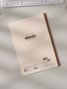 Vista posterior detallada de un cuaderno B5 de líneas crema minimalista con dibujos de perros