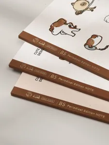 Primer plano de tres cuadernos B5 con lomo marrón y portadas con diseños de animales.