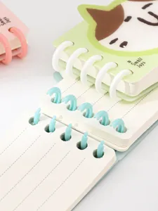 Primer plano del cuaderno de bolsillo con anillas de espiral de plástico extraíbles y líneas.