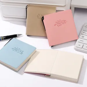 Close-up of portable small leather notebook with cute animal embossing and open blank pages.