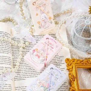 Primo piano dettagliato di simpatici blocchetti per appunti a tema coniglietto con perle e libri.