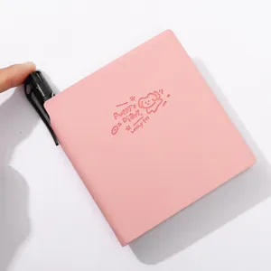 Pink pocket notebook detail with embossed puppy design, portable soft leather journal with pen