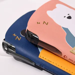 Close-up detail of pocket notebooks with cute embossed bear and leather texture.