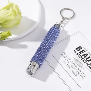 Close-up of stylish purple rhinestone LED flashlight keychain with heart cutouts