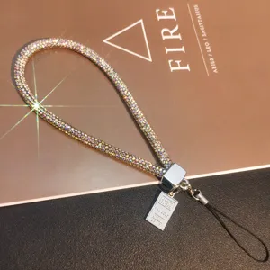 Macro view of luxury sparkling rhinestone phone wrist strap with gold bar charm