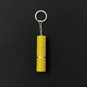 Close-up of portable 5ml perfume atomizer keychain covered in yellow rhinestones