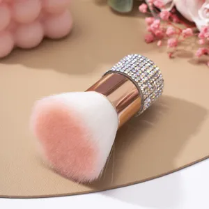 Gros plan d'un pinceau à ongles en strass avec des poils dégradés rose et blanc doux