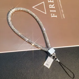 Detailed view of luxury full rhinestone phone wrist strap with embossed Queen charm