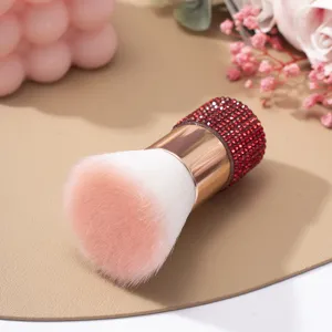 Gros plan détaillé d'un pinceau à poussière d'ongles avec manche en strass rouges