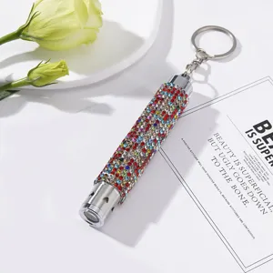 Detailed view of a mini LED flashlight keychain embellished with colorful rhinestones.