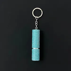 Close-up of a sparkling teal rhinestone-encrusted perfume atomizer keychain