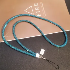 Detailed macro view of a sparkling blue rhinestone phone neck strap with silver clasp and cord