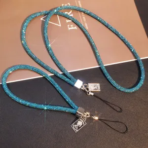 Close-up detail of luxury blue rhinestone phone lanyards with silver portrait charms.