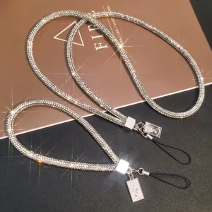 Close-up of luxury sparkling rhinestone phone lanyards with silver portrait charms.