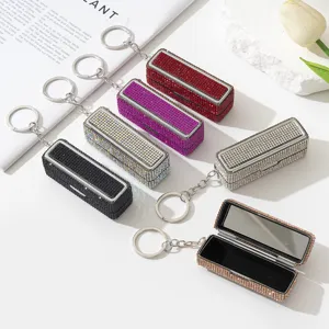 Detailansicht luxuriöser, kristallbesetzter Lippenstiftetuis mit Spiegeln und Schlüsselanhängern.