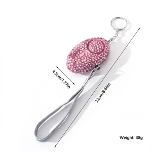 Close-up detail of a pink rhinestone personal alarm showing 38g weight and dimensions