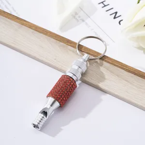 Detail of survival whistle with red rhinestones and aluminum alloy keychain attachment