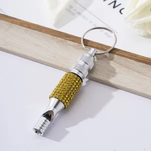 Detailed view of silver aluminum alloy survival whistle decorated with yellow rhinestones