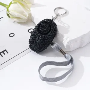 Detailed macro view of elegant black rhinestone personal security alarm for women protection.