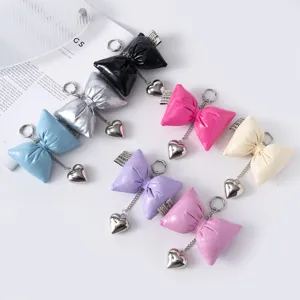 Collection of puffy faux leather bow keychains with silver heart pendants in various colors