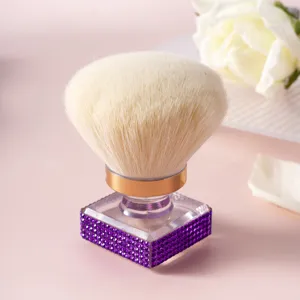 Détail d'un pinceau de maquillage orné de strass violets avec une tête douce et duveteuse