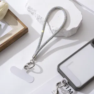 Glinsterende zilveren strass telefoon polsband met witte universele bevestigingspad.