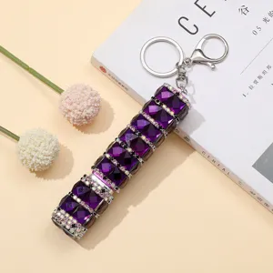 Detalle del atomizador de perfume de cristal morado con pedrería de 10 ml con llavero
