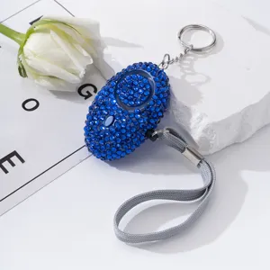 Blue rhinestone-encrusted personal safety alarm keychain for women's self-defense detail.