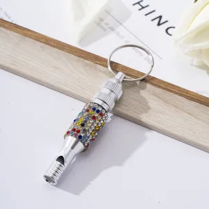 Close-up of a rhinestone aluminum whistle keychain for outdoor survival training