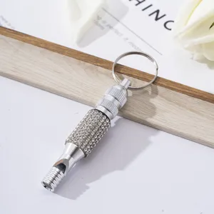 Macro view of a silver aluminum emergency survival whistle with sparkling rhinestone detailing
