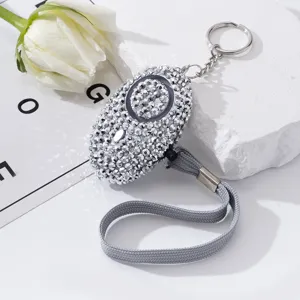 Detail view of a sparkly rhinestone personal safety alarm with keychain