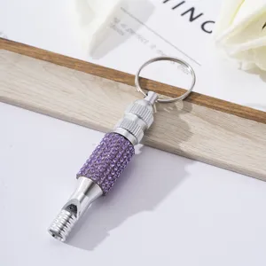 Close-up of purple rhinestone decorated aluminum alloy survival whistle keychain