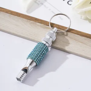 Close-up view of a diamond-encrusted aluminum alloy whistle featuring blue rhinestones