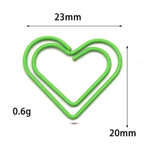 Vista detallada de clip de papel metálico verde en forma de corazón, marcapáginas.