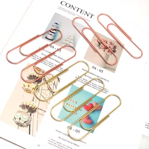 Detailed shot of large 100mm metal paper clips in rose gold and gold for office use.