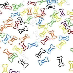 Gedetailleerd overzicht van verspreide kleurrijke botvormige paperclips voor briefpapier.